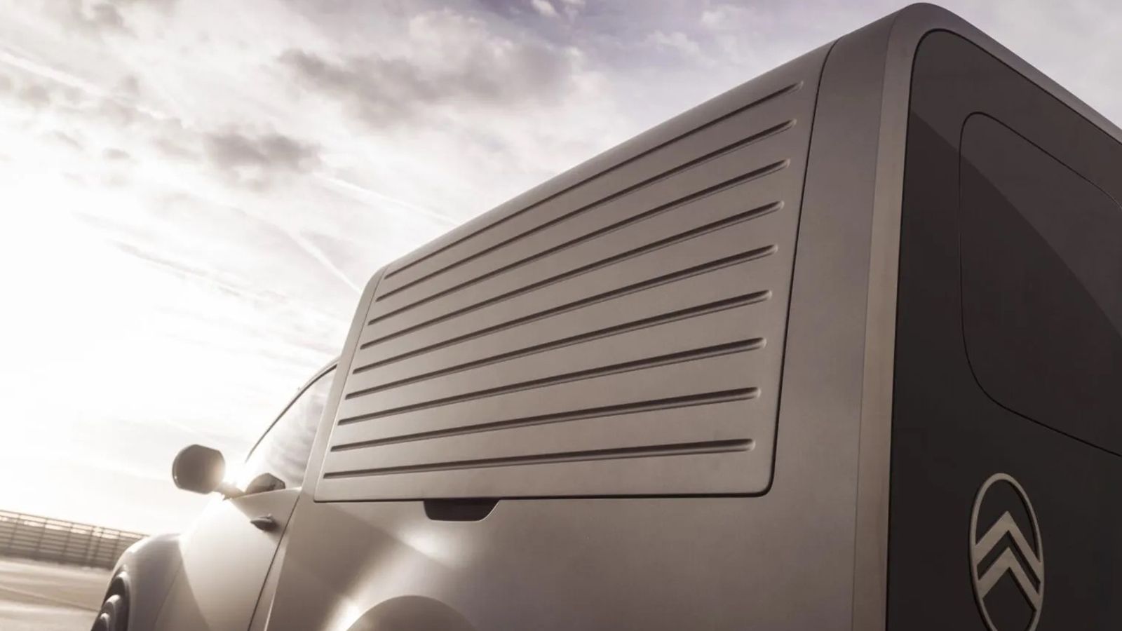 Κοντινή λήψη της πίσω γωνίας του Citroen 2CV Fourgonnette concept van που εστιάζει στις ανάγλυφες λωρίδες του πάνελ και στο σήμα της Citroen.