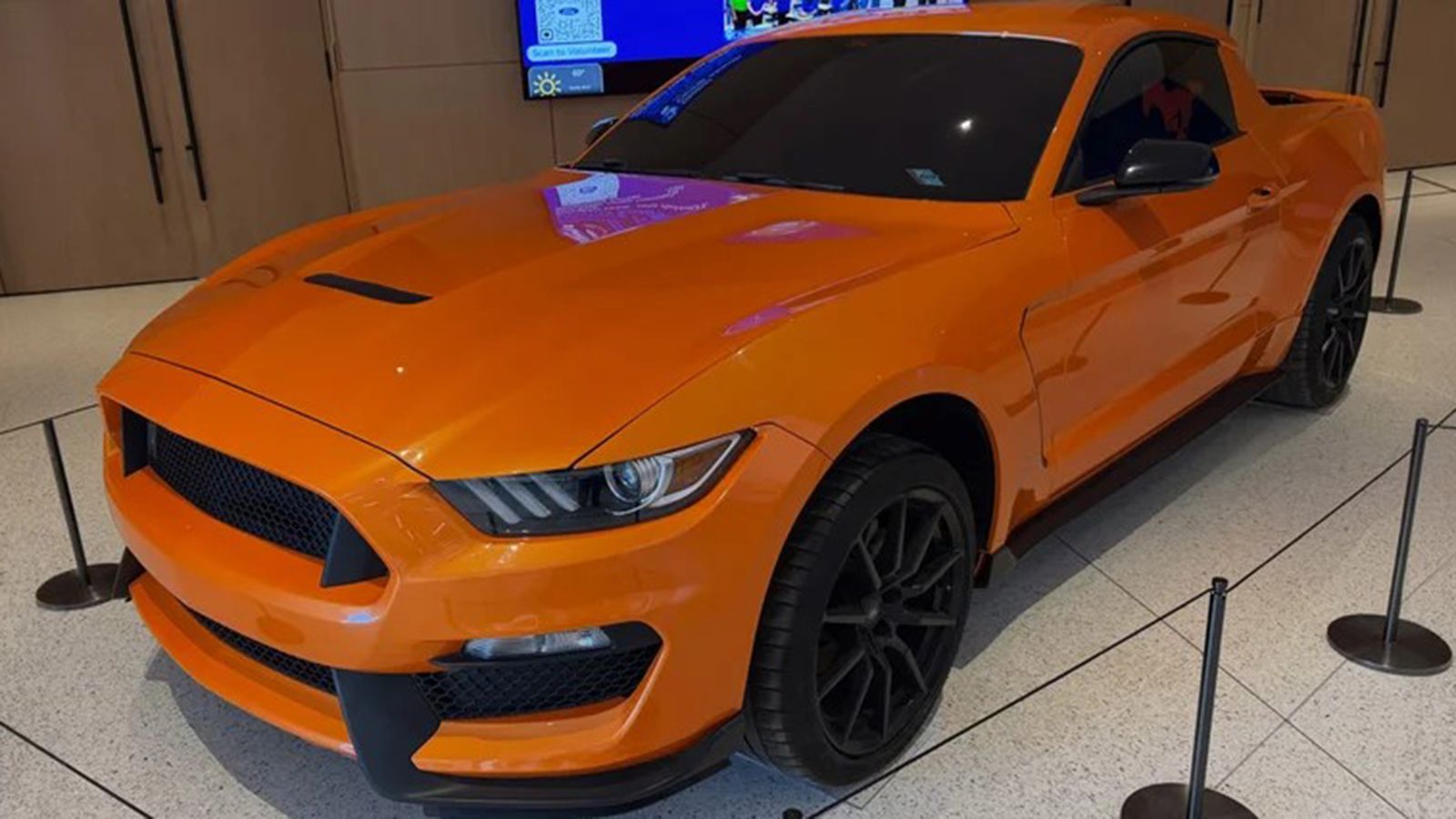 Η πορτοκαλί Mustang Pick-Up από εμπρός αριστερά, με μεγάλες εισαγωγές αέρα και αεριζόμενο καπό.