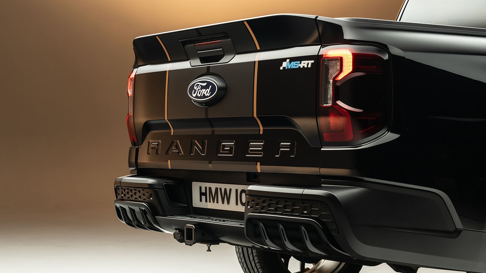 Κοντινό πλάνο στο πίσω μέρος του Ford Ranger MS-RT Champion Edition, που δείχνει την πίσω πόρτα με τη χρυσή λωρίδα, το σήμα MS-RT, τα LED φωτιστικά σώ