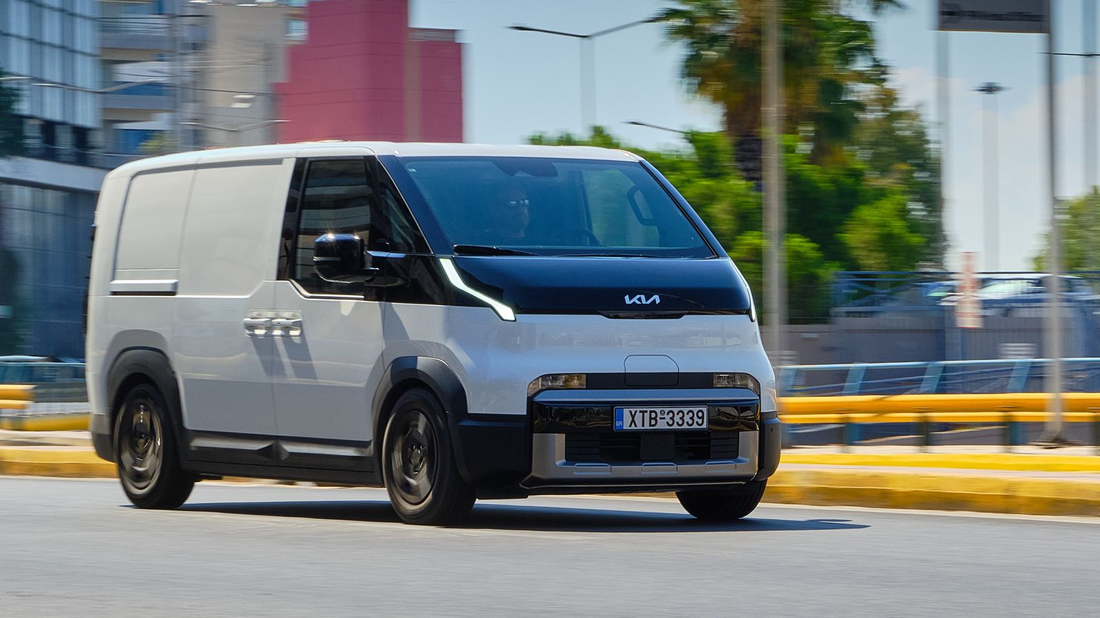 Λευκό Kia PV5 Cargo κινείται σε αστικό περιβάλλον στην Ελλάδα, εμπρός κίνηση, ηλεκτρικό μικρό van
