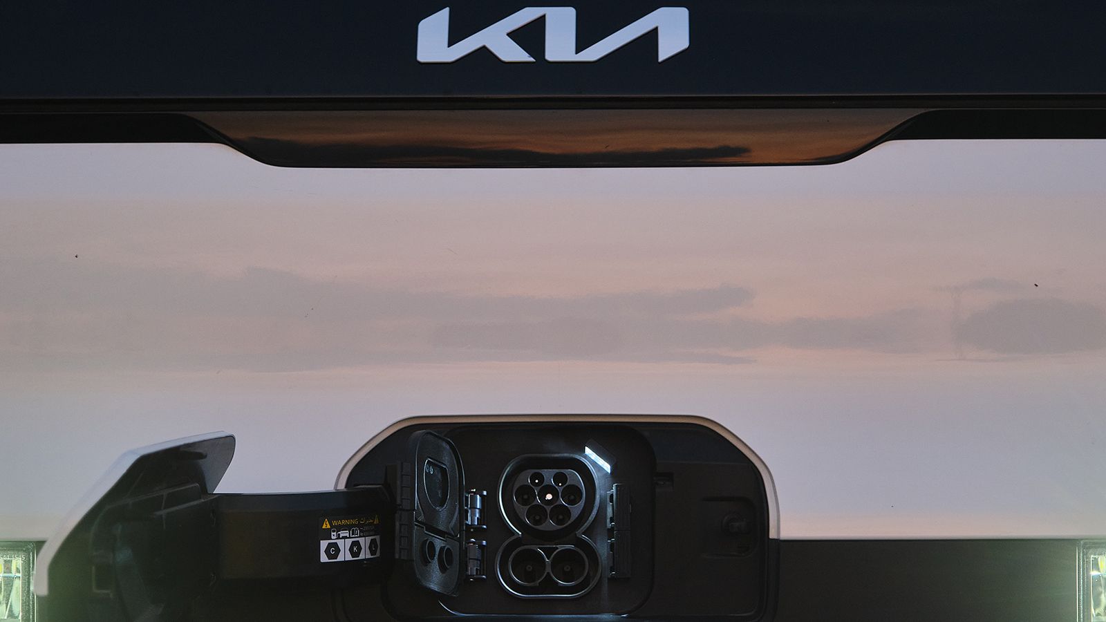 Κοντινό στη θύρα φόρτισης του Kia PV5 Cargo, δυνατότητα ταχυφόρτισης DC και φόρτισης AC.