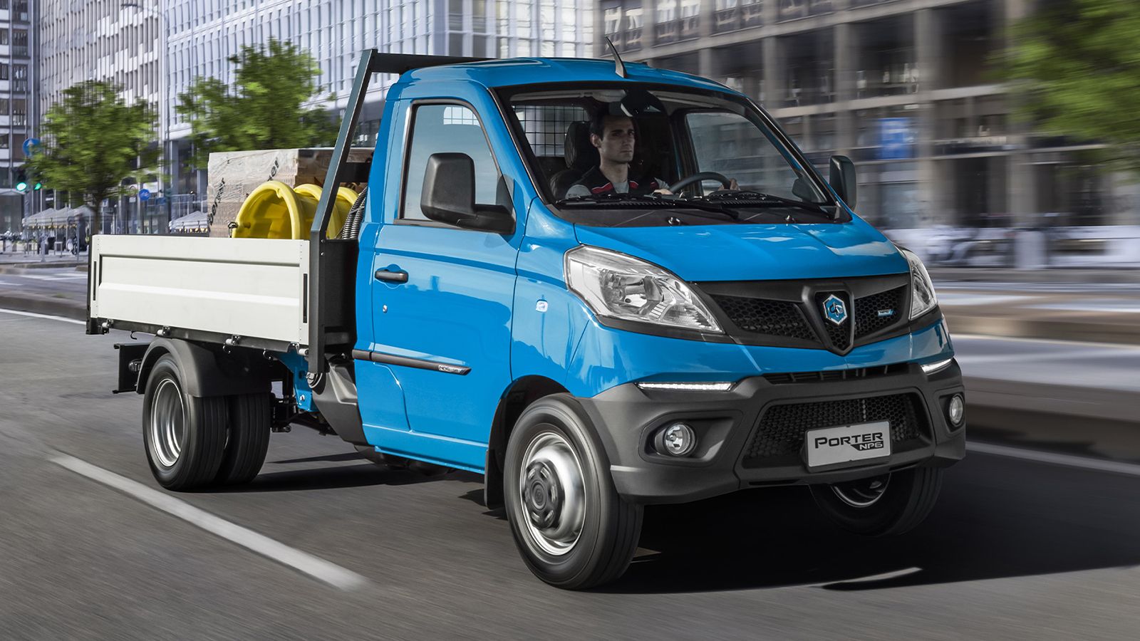 Μπλε Piaggio Porter NP6 LPG με σταθερή ανοικτή καρότσα σε αστικό δρόμο