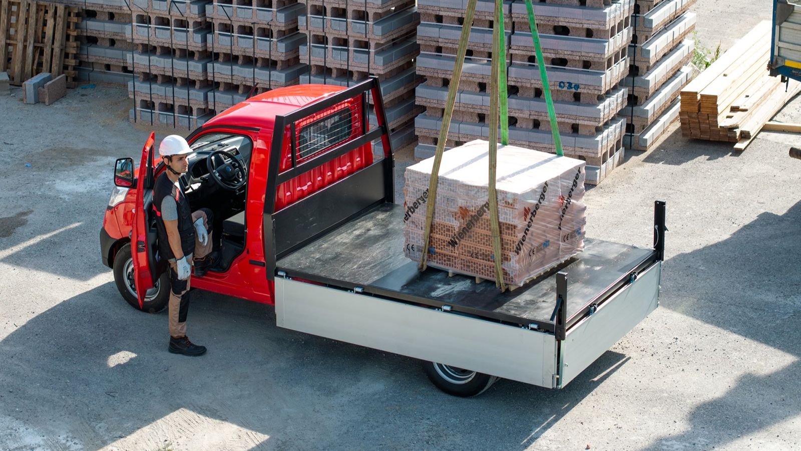Κόκκινο Piaggio Porter NP6 με ανοικτή σταθερή καρότσα κατά τη φόρτωση οικοδομικών υλικών