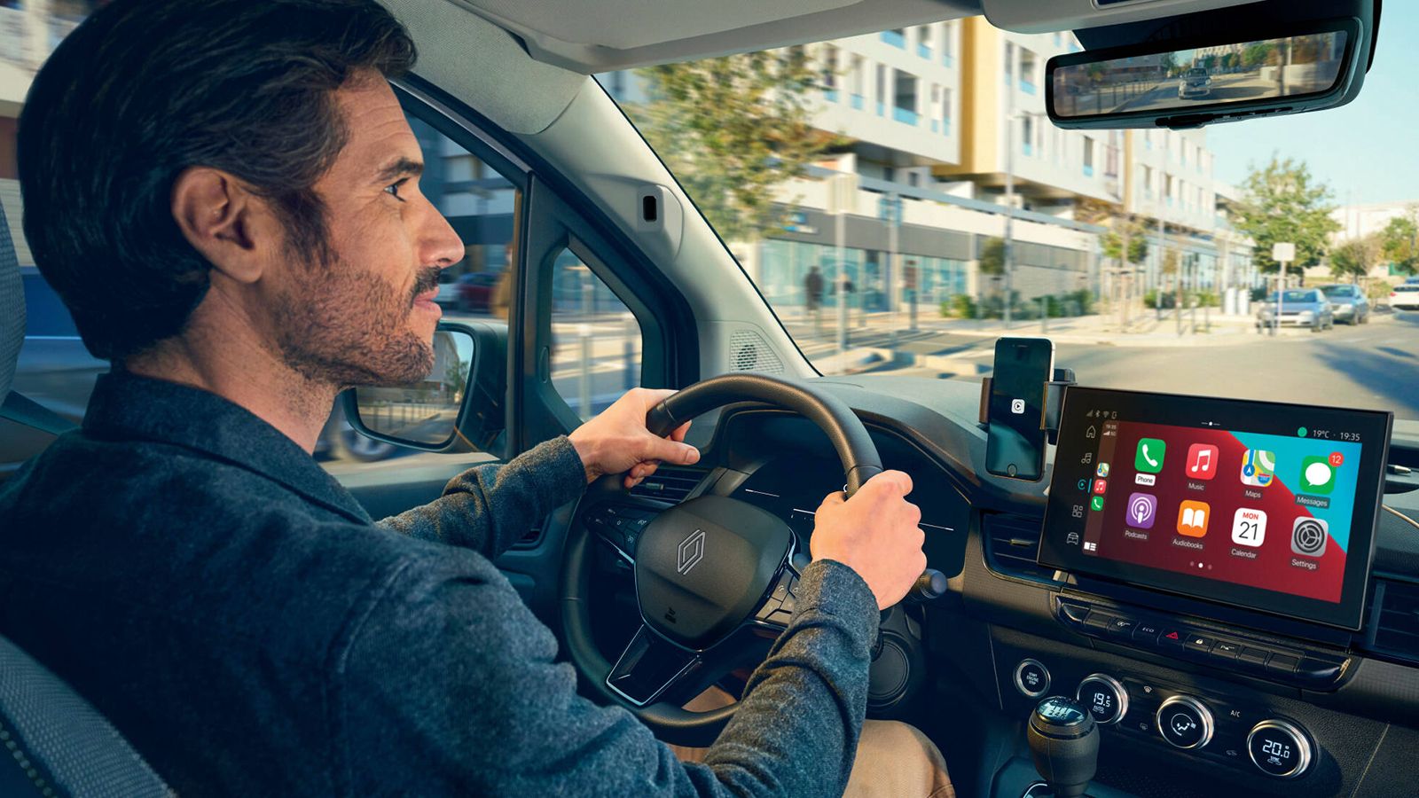 Οδηγός Renault Kangoo Van με το Apple CarPlay να εμφανίζεται στην κεντρική οθόνη του ταμπλό.