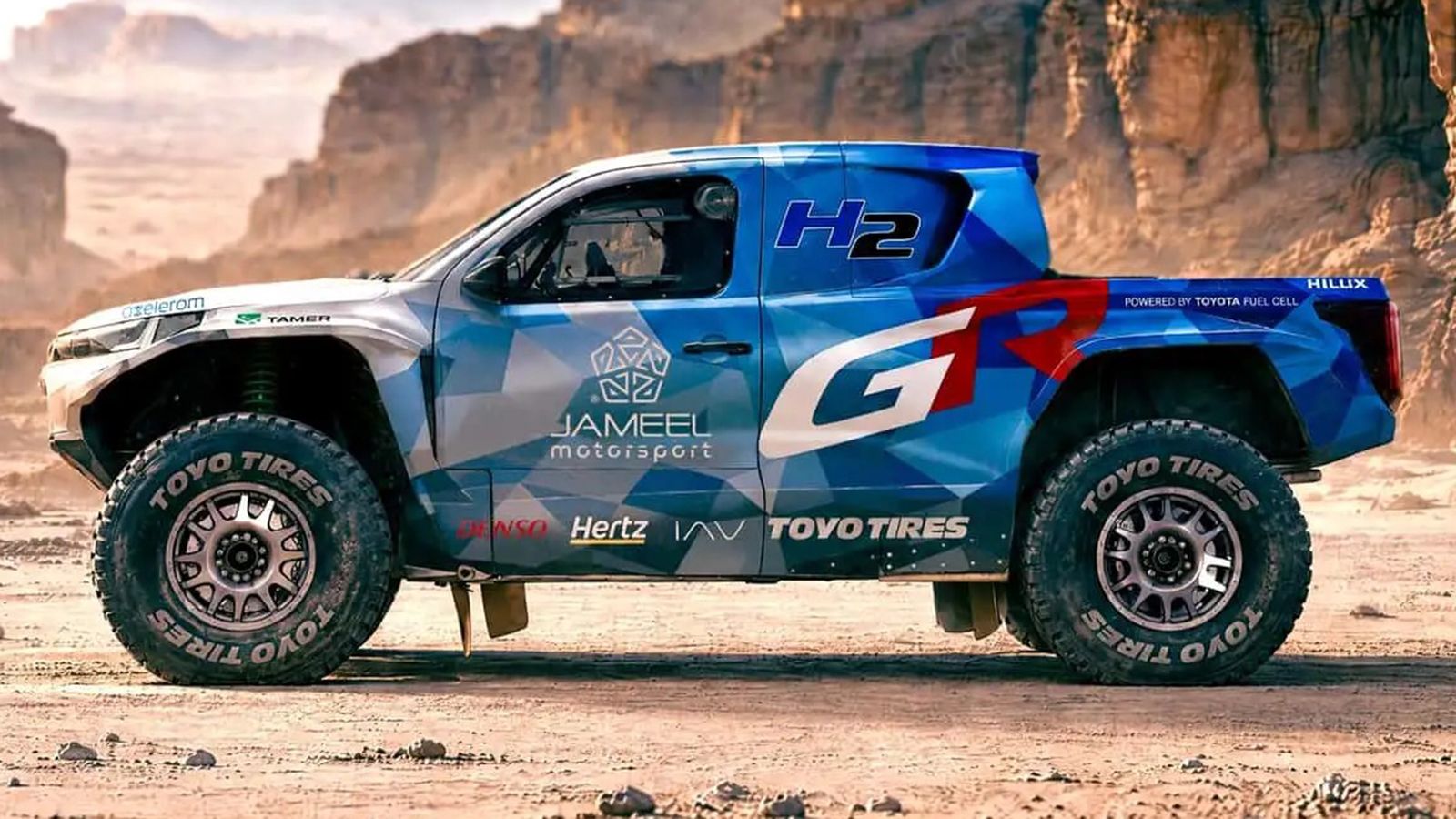 Πλάγια όψη του Toyota DKR GR FC Hilux με σήμανση H2 και GAZOO Racing.