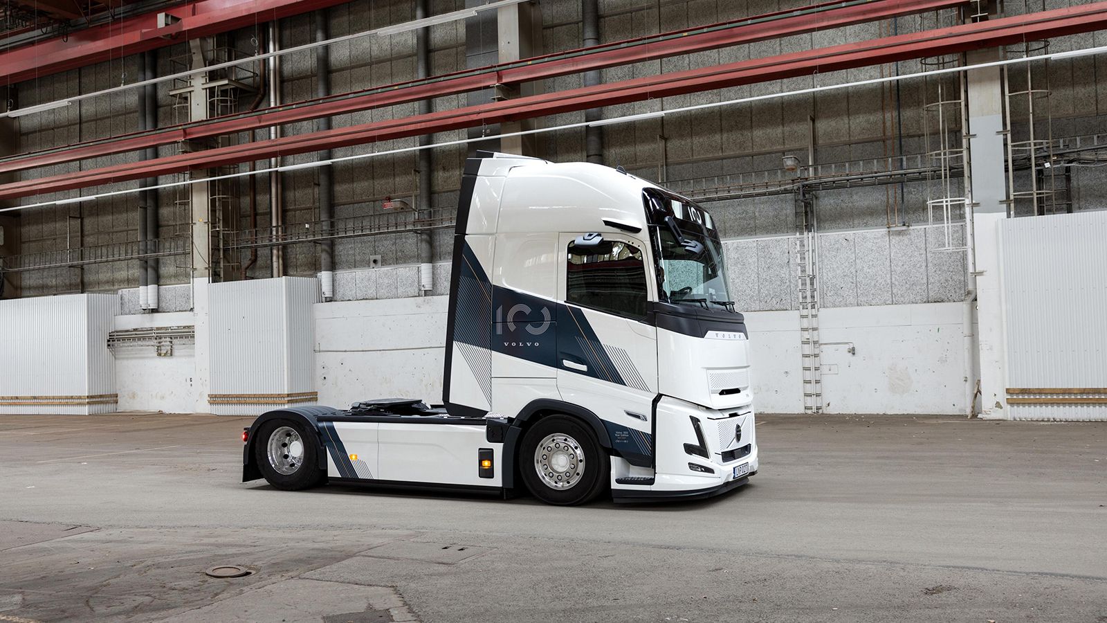 Λευκό φορτηγό Volvo FH 100 Year Edition μέσα σε βιομηχανικό κτίριο