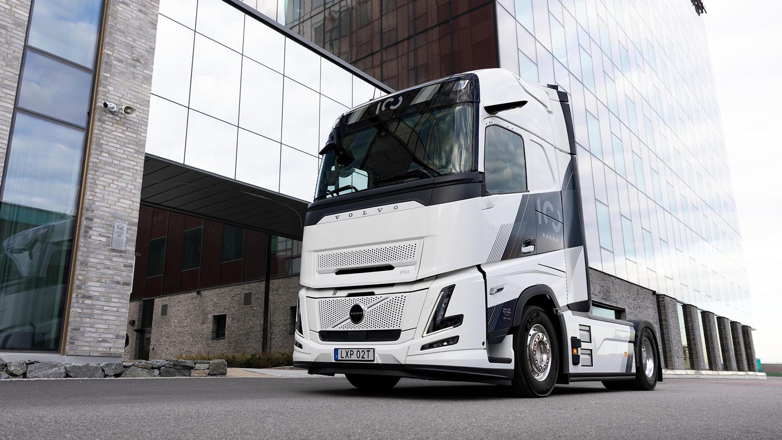 Λευκό Volvo FH 100 Year Edition σταθμευμένο μπροστά σε σύγχρονο κτίριο