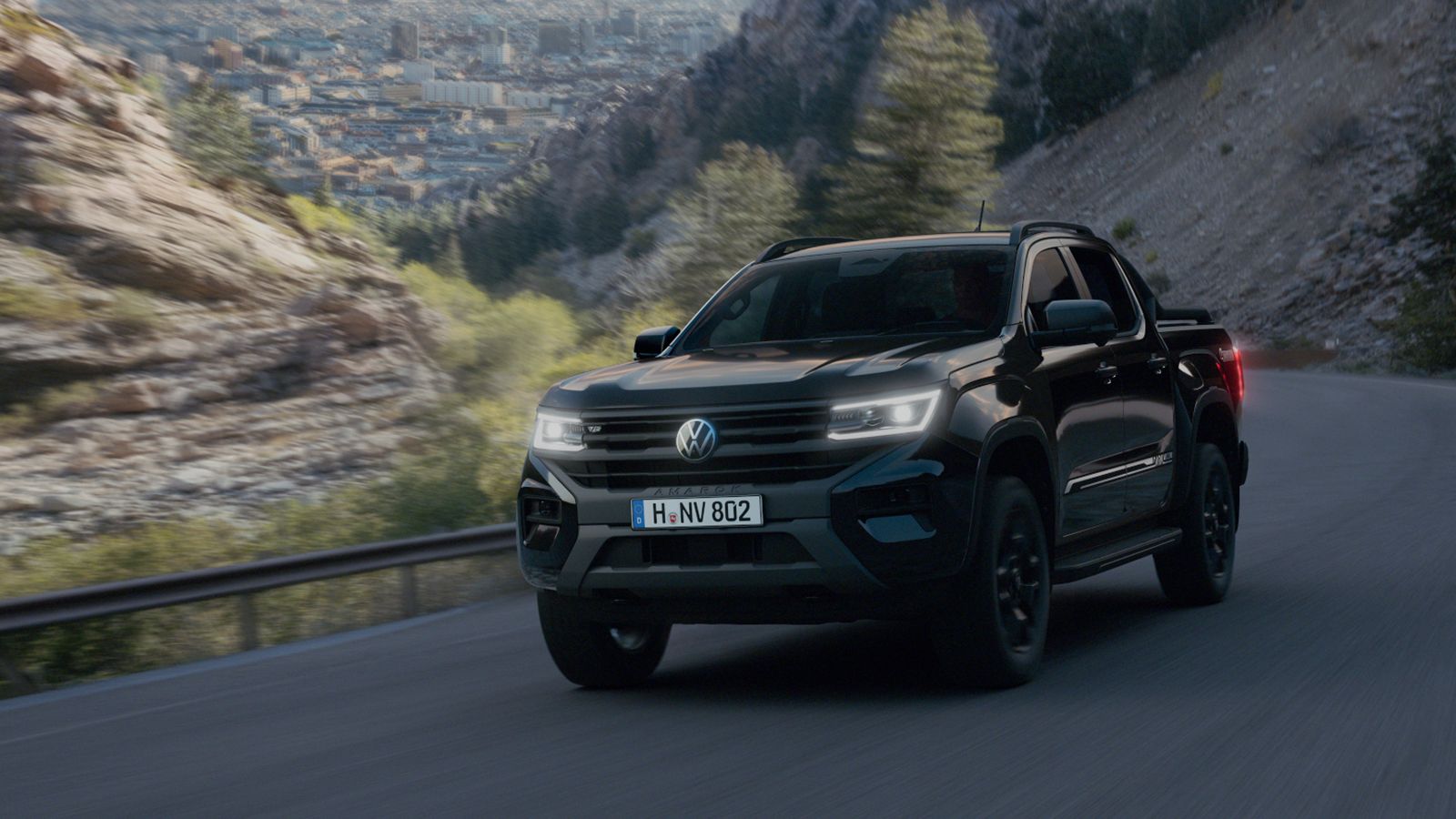 Volkswagen Amarok Dark Label σε κίνηση σε ορεινό ασφαλτοστρωμένο δρόμο